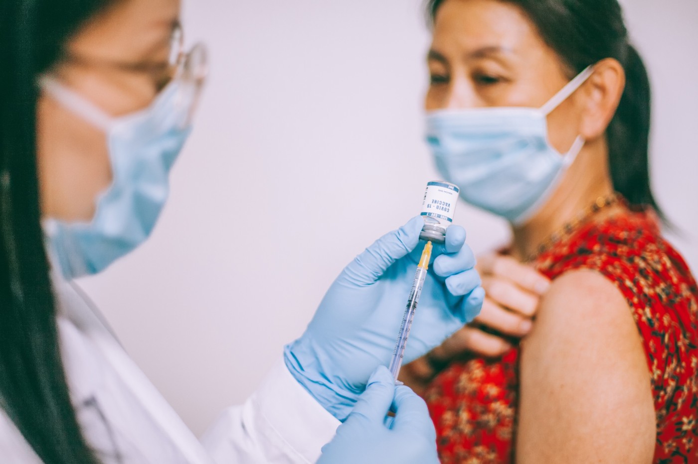https://tickertapecdn.tdameritrade.com/assets/images/pages/md/health care professional giving covid-19 vaccine to woman: post-COVID investing opportunities and risks